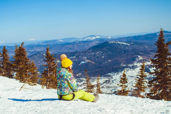 Dziewczyna siedzi na górze w zimie — Zdjęcie stockowe