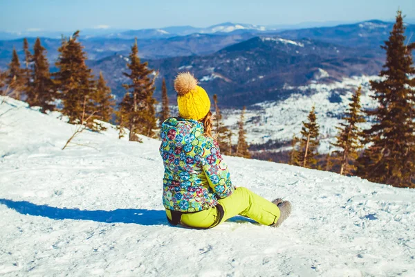 A menina senta-se no topo no inverno — Fotografia de Stock