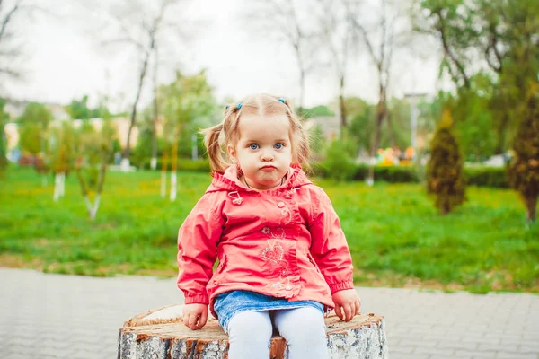 Menina sentada em um toco — Fotografia de Stock