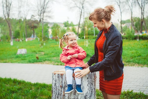 Dívka sedící na pařezu — Stock fotografie