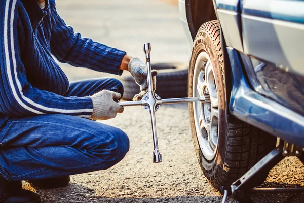 Mand skiftende hjul på en bil - Stock-foto