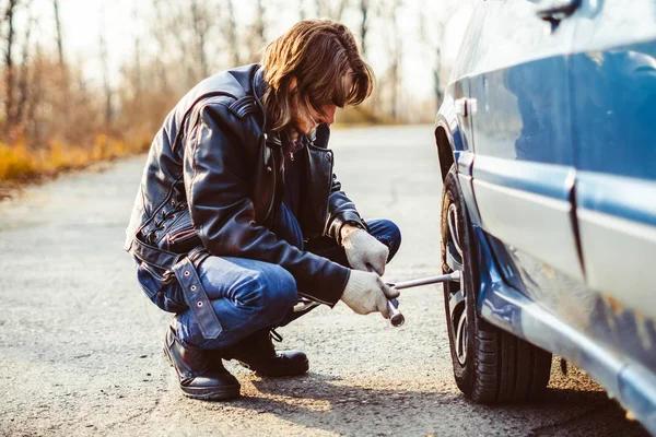 男は車の上でホイールを変更します。 — ストック写真