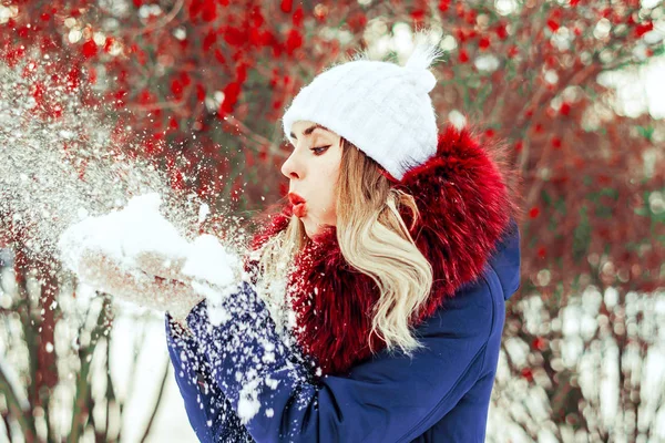 Mujer soplando nieve en las manos — Foto de Stock