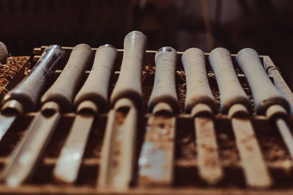 Old used wood lathe chisels selection on the dark wooden table — Stock Photo, Image