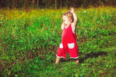 Çocuk çimenlerin üzerinde yürümeyi öğrenir