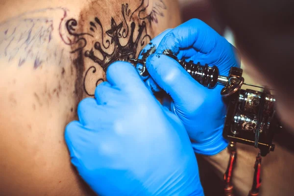 Mestre tatuagem mulher em suas costas — Fotografia de Stock