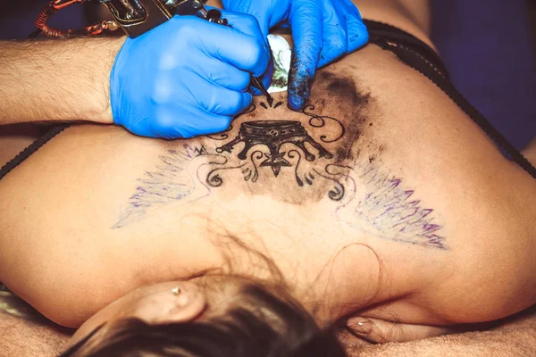 Mestre tatuagem mulher em suas costas — Fotografia de Stock
