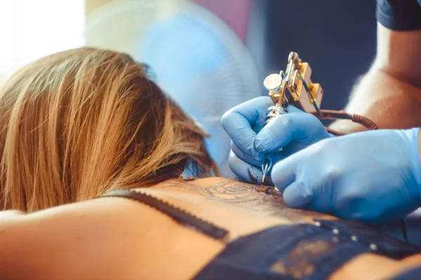 Master tattoo woman on her back — Stock Photo, Image