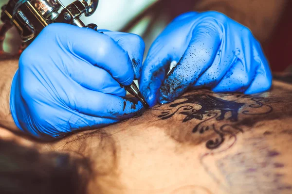 Mestre tatuagem mulher em suas costas — Fotografia de Stock