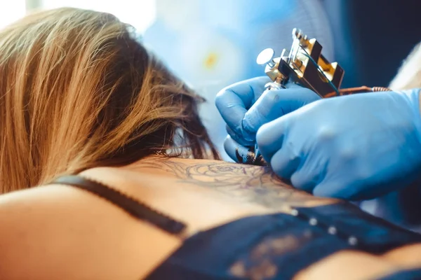 Master tattoo woman on her back — Stock Photo, Image