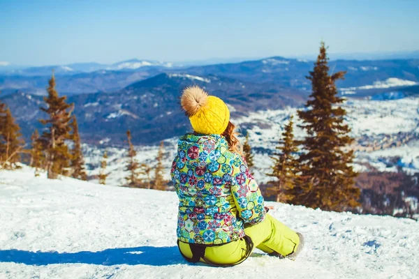 Das Mädchen sitzt im Winter oben — Stockfoto