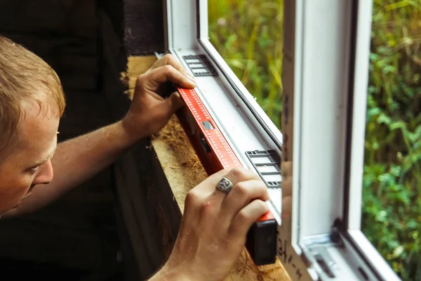 Trabajador comprueba el nivel de una ventana — Foto de Stock