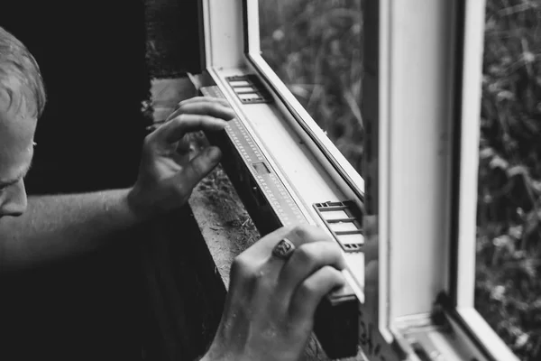 Arbeiter überprüft das Niveau eines Fensters — Stockfoto