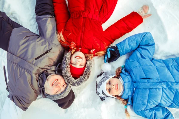 Rodzina z dzieckiem leżącego w śniegu — Zdjęcie stockowe
