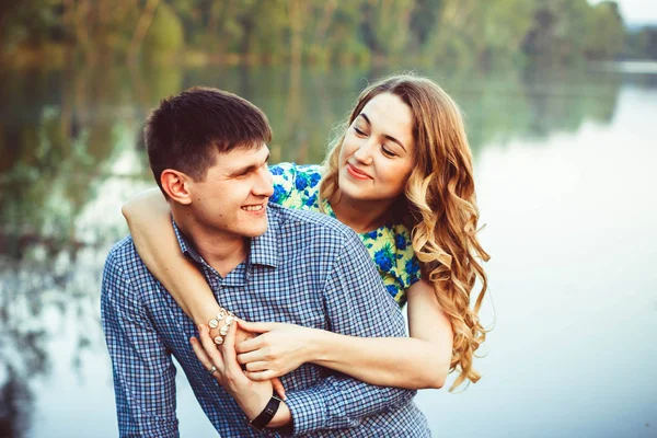 Young couple kissing and rejoices at the lake. — Stock Photo, Image