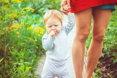 Çocuk çimenlerin üzerinde yürümeyi öğrenir