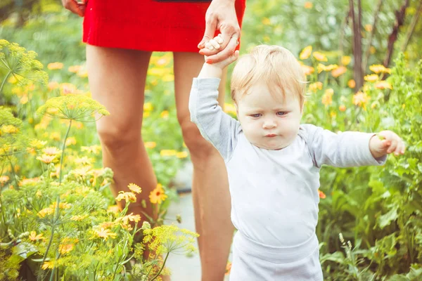 Het kind leert om op het gras te lopen — Stockfoto