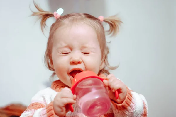 Lilla flickan dricka från en flaska — Stockfoto