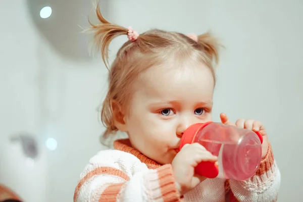 Lilla flickan dricka från en flaska — Stockfoto