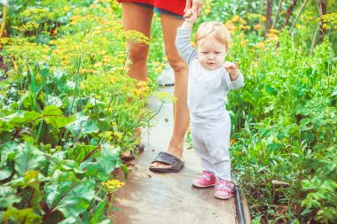 Çocuk çimenlerin üzerinde yürümeyi öğrenir