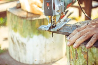 Elektrikli testere kullanarak koruma eldivenli adam