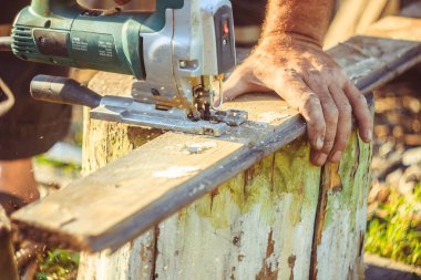 Elektrikli testere kullanarak koruma eldivenli adam