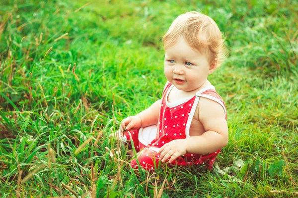 子供は草の上に座っていて — ストック写真