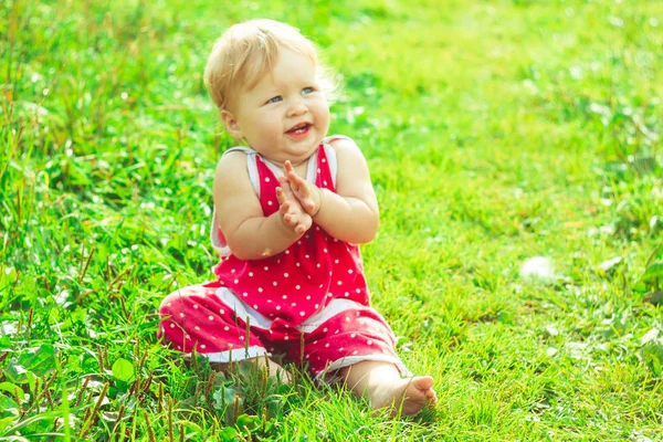 L'enfant est assis sur l'herbe — Photo