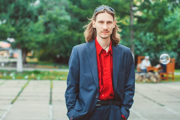 De man in de jas met lange haren — Stockfoto