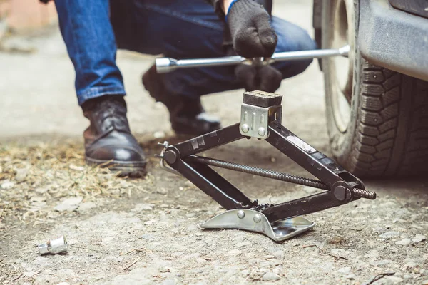 Homme changeant de roue sur une voiture — Photo