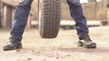 Garajda araba lastiği tutan makinist