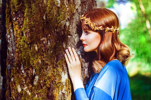 Una mujer junto al tronco de un árbol —  Fotos de Stock