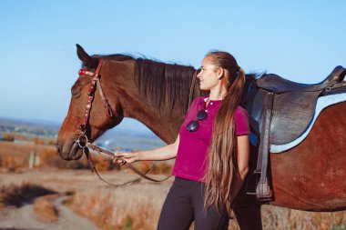 Genç ve güzel bir kız atı okşadı.