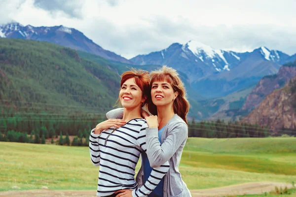 Due ragazze in piedi contro le montagne — Foto Stock