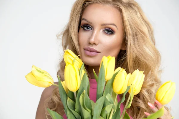 Blondýnka s žluté tulipány — Stock fotografie