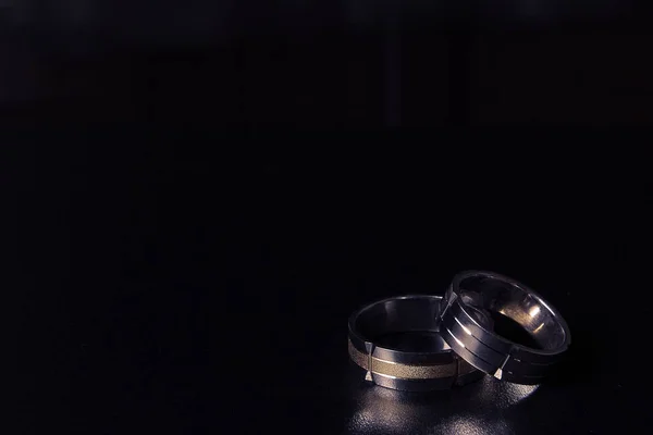 Pair of golden wedding rings on black background — Stock Photo, Image