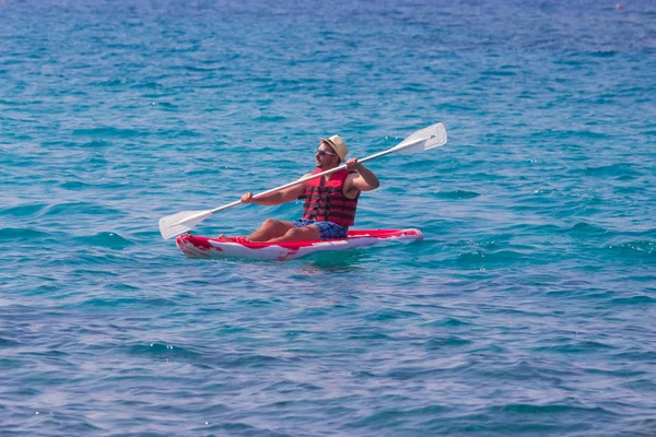 Hombre rema un kayak rojo — Foto de Stock