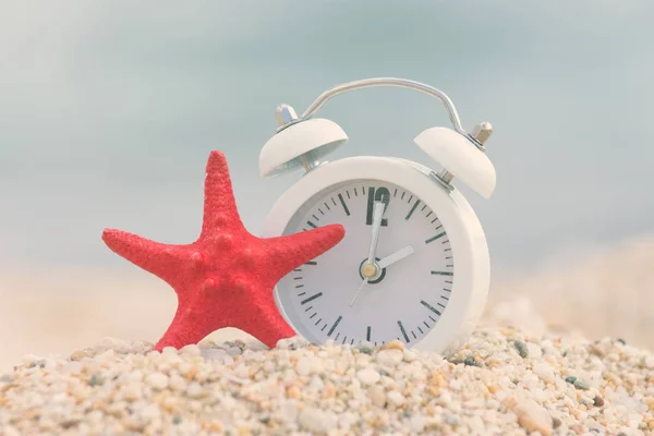 Alarm clock and seastar on the beach. Summertime concept. — Stock Photo, Image