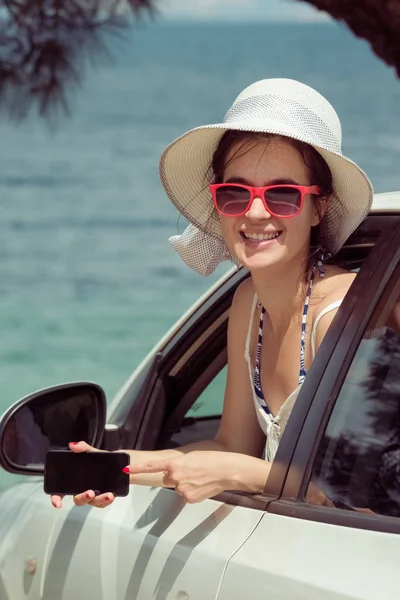 Frau im Auto mit leerem Bildschirm Smartphone-Display. Reise- und App-Konzepte. — Stockfoto