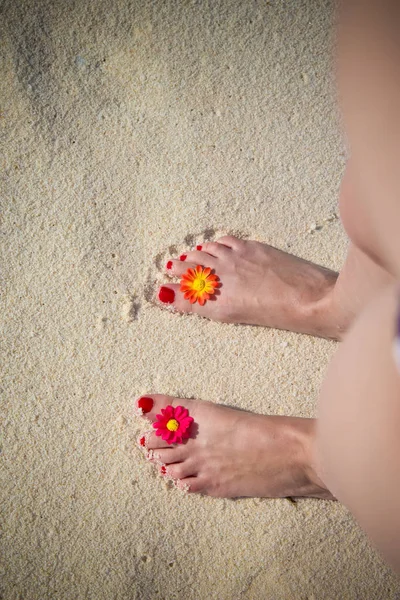 Vista dall'alto verso il basso di piedi femminili con decorazione floreale in sabbia. Concetto di ora legale . — Foto Stock