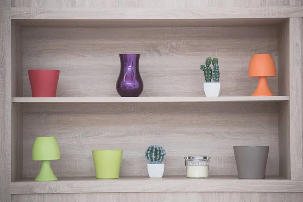 Vasos decorativos e lâmpadas na prateleira de madeira — Fotografia de Stock