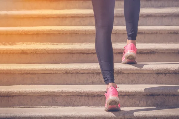 Corredor femenino con piernas atléticas corriendo por las escaleras al aire libre —  Fotos de Stock
