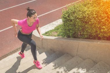 Merdivenlerden yukarı açık havada çalışan kadın koşucu 