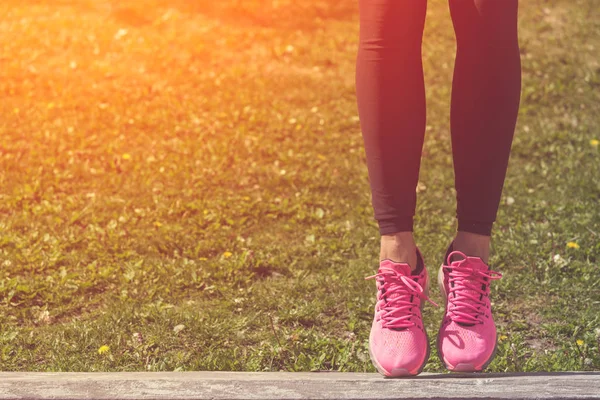 Primer plano de las piernas de jogger femenino con sportshoes en ba hierba verde —  Fotos de Stock