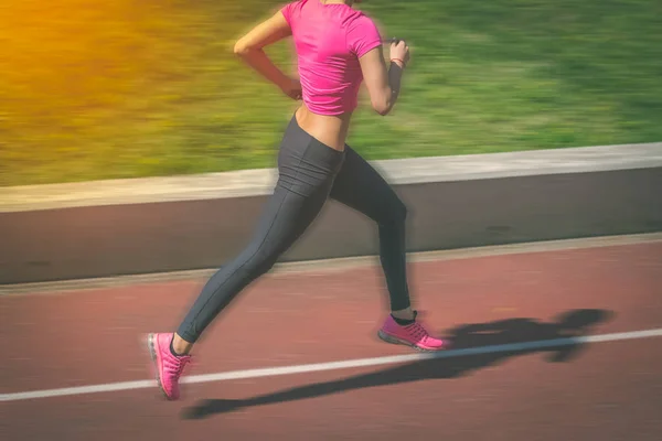 Corredor feminino correndo em pista atlética. Desfoque de movimento . — Fotografia de Stock