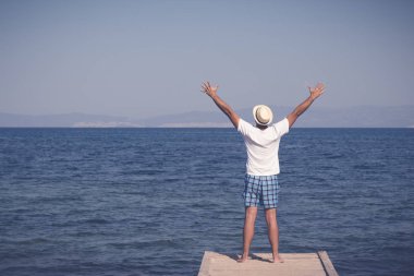 Adam ayakta bir iskelesi ucunda yalnız Kaldır ellerini ile zevk