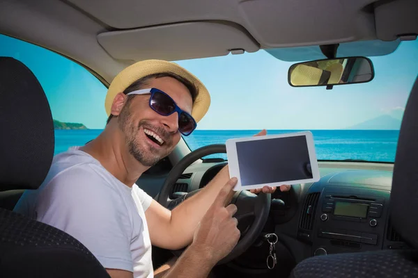 Hombre en el coche mostrando pantalla en blanco dispositivo de tableta digital. Viajar un — Foto de Stock