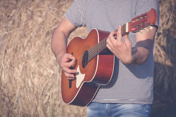 Açık havada akustik gitar çalmak adam elinde kapatın. Retro, m