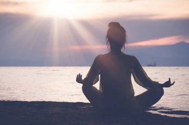 Gün batımında sahilde meditasyon erkek