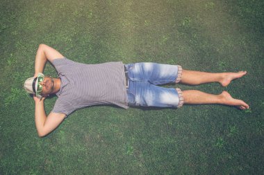 adam yeşil çim üzerinde yalan